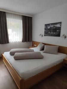 Un dormitorio con dos camas y una ventana en Apart Alina, en Galtür