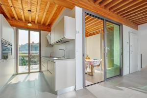 een keuken met witte kasten en glazen schuifdeuren bij Villa Mathis - by And service in Casa Tamponi