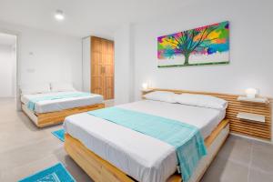 een slaapkamer met twee bedden en een schilderij aan de muur bij Villa Mathis - by And service in Casa Tamponi +23 foto's