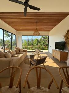 a living room with a couch and a flat screen tv at Julim Flora - Eco Villa in Amed
