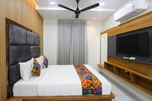 a bedroom with a bed and a flat screen tv at Hotel Narayan Villa in Rājahmundry