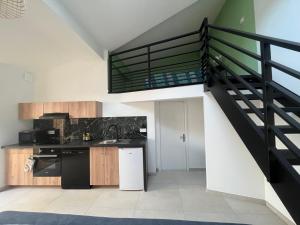une cuisine avec un escalier menant à un loft dans l'établissement La Vie est Belle, à Saint-Symphorien-sur-Coise