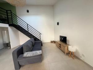 un salon avec un canapé et une télévision à écran plat dans l'établissement La Vie est Belle, à Saint-Symphorien-sur-Coise