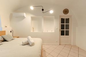 - une chambre blanche avec un lit et 2 oreillers dans l'établissement le cocon de Montélimar, à Montélimar