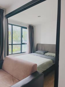 a bed in a room with a large window at 47near Shopping Malls and Naka night market in Phuket Town +29 photos