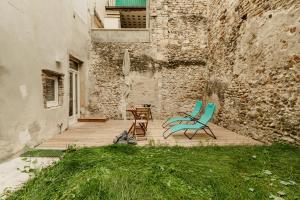 deux chaises et une table sur une terrasse à côté d'un bâtiment dans l'établissement le cocon de Montélimar, à Montélimar