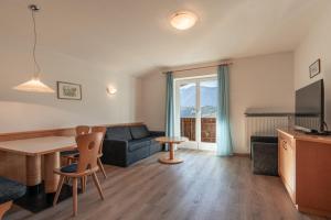 un salon avec un canapé et une table dans l'établissement Petaunerhof, à Schenna