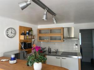 une cuisine avec un évier et une horloge murale dans l'établissement T2 de la Bastide Rouge vue exceptionnelle (180°) sur Aix domaine privé T2 indépendant de 37 m2 avec terrasse exposée plein sud Piscine 10 X 5, à Aix-en-Provence