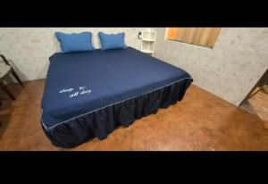 a bed with blue sheets and blue pillows on it at Red Lantern guesthouse in San Fernando