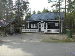 a black and white house with a white fence at Aamuaurinko in Korospohja