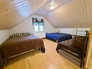 a attic bedroom with two beds and a window at Aamuaurinko in Korospohja