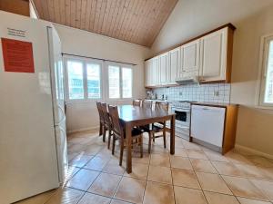 a kitchen with a table and chairs and a refrigerator at Aamuaurinko in Korospohja
