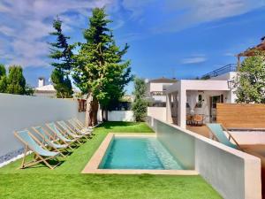 een achtertuin met stoelen en een zwembad bij Apartaments Gorgot in Empuriabrava