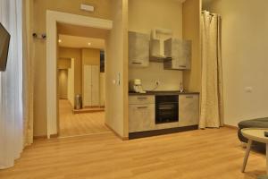 een keuken met roestvrijstalen apparatuur en een woonkamer bij Morina Rooms in Trieste +31 foto's