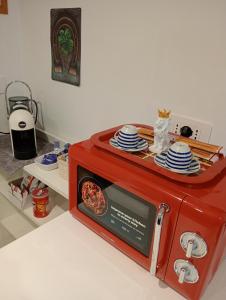 eine rote Mikrowelle mit Tellern darauf in der Unterkunft Lyon Vischi in Trani