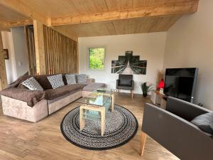 un salon avec un canapé et une télévision dans l'établissement Villa Reignier, à Reignier-Ésery