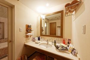 a bathroom with a sink and a large mirror at Hotel NOON in Kawaguchi