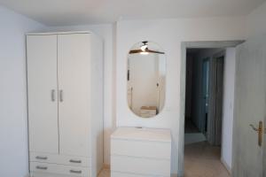 ein weißes Badezimmer mit Waschbecken und Spiegel in der Unterkunft APARTAMENTO LOS BATELES - Frente a la playa in Conil de la Frontera + 10 Fotos