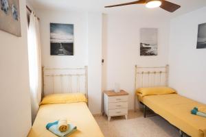 Zimmer mit 2 Betten und einem Deckenventilator in der Unterkunft APARTAMENTO LOS BATELES - Frente a la playa in Conil de la Frontera