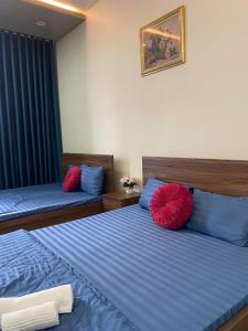 a bedroom with two beds with blue and red pillows at Cibi's Homestay - Tra Khuc riverside in An Bình (1)