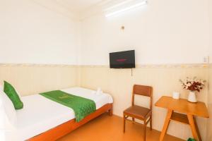 a small room with a bed and a chair at Thanh Long Hotel Hồ Chí Minh in Ho Chi Minh City
