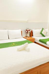 two beds in a room with flowers on them at Thanh Long Hotel Hồ Chí Minh in Ho Chi Minh City