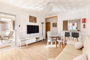 a living room with a couch and a table with chairs at La historia de la Casa de los Gatos in Los Narejos