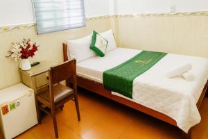 a small room with a bed and a chair and a desk at Thanh Long Hotel Hồ Chí Minh in Ho Chi Minh City +12 photos