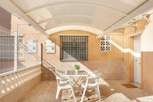 a room with a table and chairs on a balcony at La historia de la Casa de los Gatos in Los Narejos