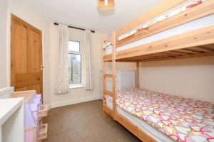 a bedroom with two bunk beds and a window at Rock View Cottage in Stanton in Peak