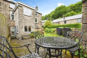 a patio with a table and chairs in a yard at Rock View Cottage in Stanton in Peak