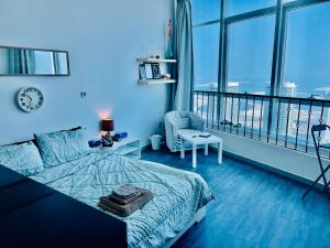 a blue bedroom with a bed and a chair at Panoramic Sea View Studio in Abu Dhabi +19 photos