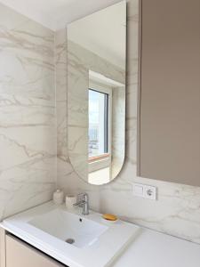 une salle de bain blanche avec un lavabo et un miroir dans l'établissement Le Luna Apart, à Braşov 13 autres photos