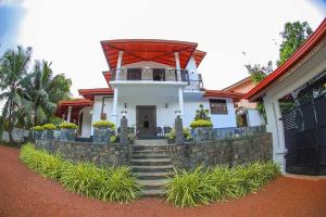 ein weißes Haus mit einer Treppe und einem Balkon in der Unterkunft Peacock Hill Villa in Matugama + 13 Fotos