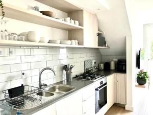 a white kitchen with a sink and a counter at The Wild Oak in Hermanus +11 photos