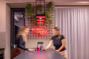 zwei Personen stehen an einem Tisch in einem Restaurant in der Unterkunft Imperial Residence - design aparthotel in city center, private parking in Banská Bystrica