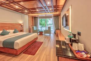 Una habitación de hotel con una cama y un comedor. en Shivalaya Retreat - A River Side Resort, en Manali