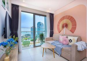 a living room with a couch and a large window at The Song Tran Van Home Vung Tau 5 Stars in Vung Tau
