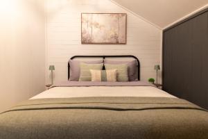 una camera da letto con un letto grande con cuscini di Cabana pe Deal a Remetea Chioarului