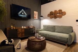 un soggiorno con un divano e una TV di Cabana pe Deal a Remetea Chioarului