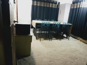 Spacious 2-Bedroom Apartment with Terrace & Multiple Bathrooms في Dargai: قاعة اجتماعات مع طاولة وكراسي زرقاء