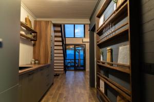 una cucina con pavimento in legno e un corridoio con finestre di Cabana pe Deal a Remetea Chioarului Altre 13 foto