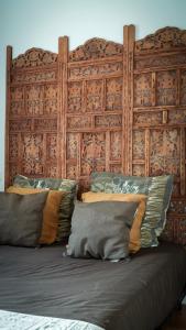 a large bed with a wooden headboard and pillows at Chambre d'hôtes Sous Les Grands Chênes NOMADE in Saint-Étienne-de-Corcoué