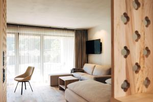 a living room with a couch and a chair at Hotel Ansitz Gamp in Chiusa