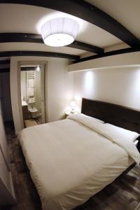 a bedroom with a large white bed and a light at San Francesco Suite in Poggio Bustone