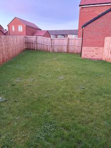une cour avec une clôture et un bâtiment en briques dans l'établissement Bettys Acklam hideout, à Middlesbrough