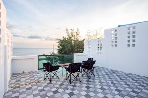 um pátio com cadeiras e uma mesa na varanda em Coral Beach House Rayong em Ban Noen Phra