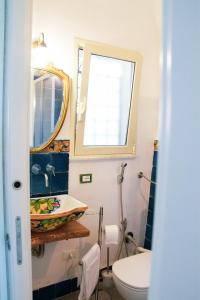 une salle de bain avec un lavabo, des toilettes et un miroir dans l'établissement DAI MORI, à Palerme