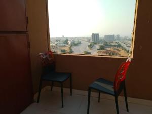 Spacious 2-Bedroom Apartment with Terrace & Multiple Bathrooms في Dargai: كرسيين ونافذة مطلة على المدينة +7 صور