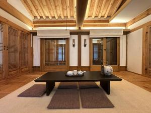 清州市Luxury Hanok Sangseon Heritage Hanok-W的客厅里有一张黑色桌子和木质天花板。